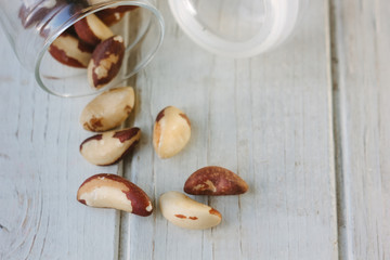 Brazil nuts and glass bottle over the white table