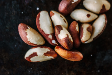 Brazil nuts on black metal board.