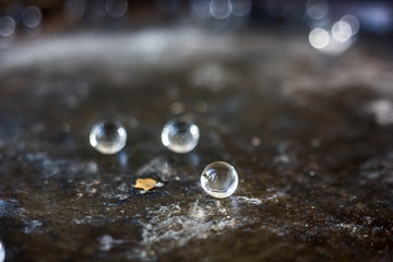 Balls of hydrogel on black metal background.