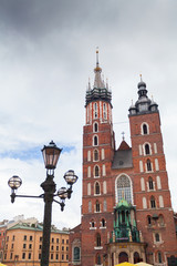 Church of St. Mary in the main Market Square on the background of dramatic sky. Basilica Mariacka. Krakow. Poland.