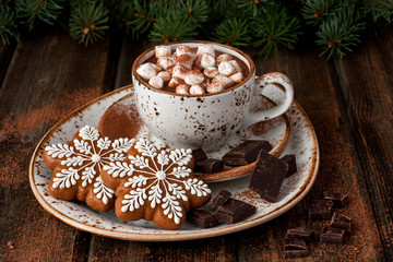 Hot cocoa with marshmallows and gingerbread cookies on the wooden background