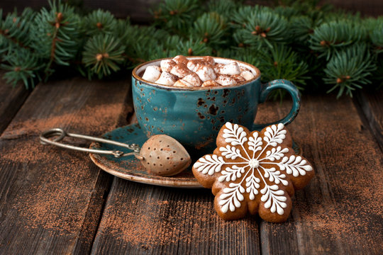 Cup of hot chocolate with marshmallows and gingerbread cookies on a wooden table