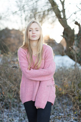 Junge Frau im rosa Pullover posiert