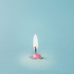 Burnt out pink candle on blue background. Minimal timeline conce