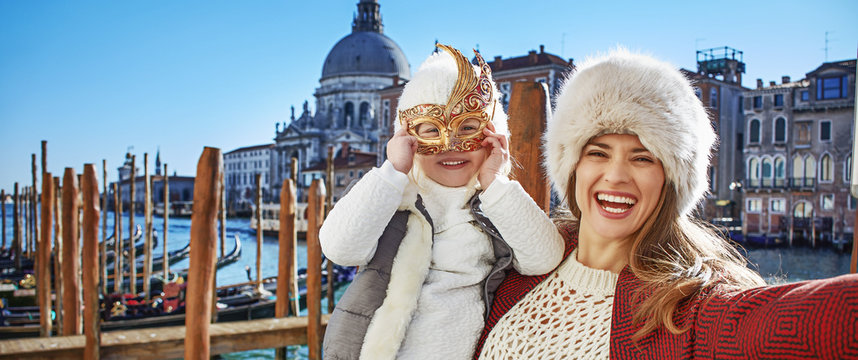 smiling mother and child travellers taking selfie in Venice