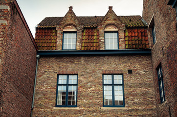 Red brick house facade with windows in Bruges, Belgium