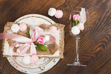 Fototapeta na wymiar Light pink roses and tableware on the wooden table
