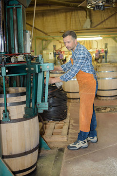 cooper making wooden wine barrels in workshop