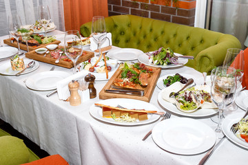 appetizers of seafood and meat on wooden plate in restaurant