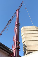 Roter Kran mit Gegengewicht aus Beton