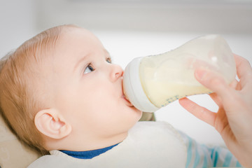 Mother feeds baby from a bottle of milk