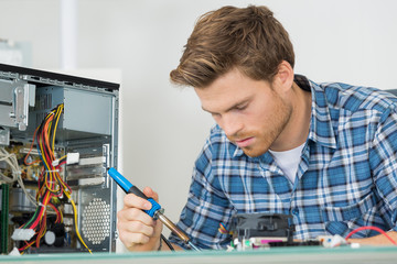 Male computer technician using soldering iron
