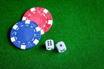 poker chips and dice on green background top view