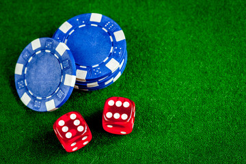poker chips and dice on green background top view