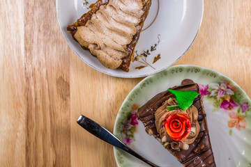 Two Chocolate Cakes on Saucer On Wooden Table Background