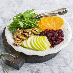 Ingredients for juicy healthy salad: arugula, green apple, walnuts, mandarin orange  a snack or lunch. Top view