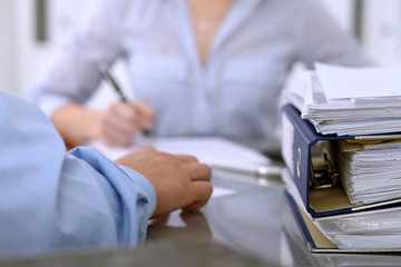 Binders with papers are waiting to be processed by bookkeepers back in blur. Accounting planning budget, audit, insurance  and business concept