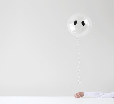 Woman's hand holding a Ghost helium balloon