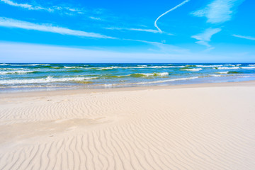 Fototapeta na wymiar Sea waves of Baltic Sea on a sandy beach in Bialogora, Poland