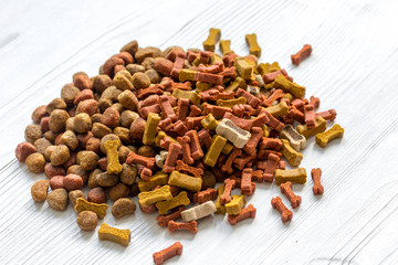 dry dog food in bulk on wooden background close up