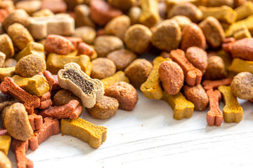dry dog food in bulk on wooden background close up