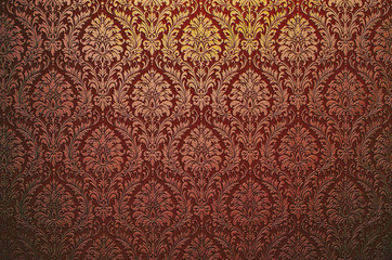 Fragment of ornamental wallpaper red blood maroon colored , or abstract surface of tiled flowers and leaves  pattern, or texture useful as a background vignetted and gradient background