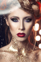 portrait of a beautiful girl with bright make-up with gold glitter