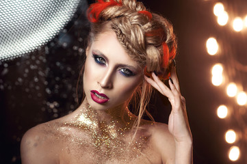 portrait of a beautiful girl with bright make-up with gold glitter