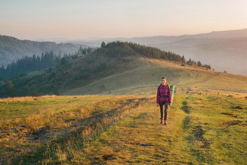 Young woman hiking with backpack in the mountain