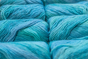 Many skeins of blue yarns are lying next to each other