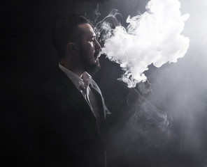Men with beard vaping on black background