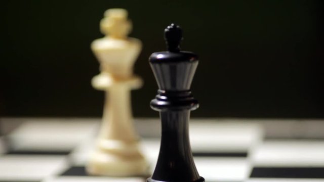 Panning shot of a chess board, with focus shifting form black king to white king.
