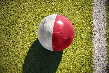 football ball with the national flag of malta lies on the field