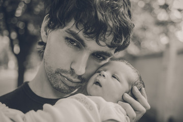 Fototapeta na wymiar The Young Thoughtful Man is Handing Newborn Baby.Black and White.