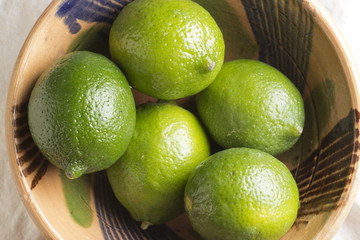 a bowl of whole fresh limes