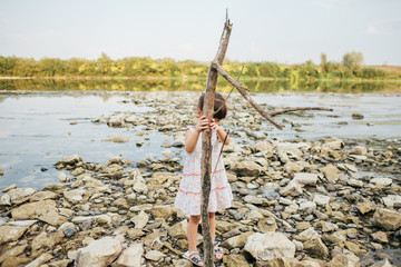 girl holding a dry branch of the river