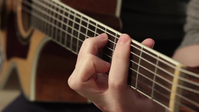 playing on the acoustic guitar. Musical instrument with guitarist hands