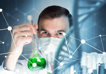 Young scientist mixing reagents in glass flask in clinical laboratory