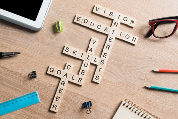 Conceptual keywords on wooden table with elements of game making crossword
