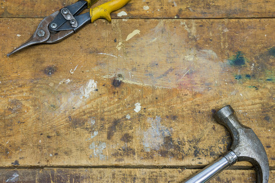 Hammer and pliers on worn wooden workshop background