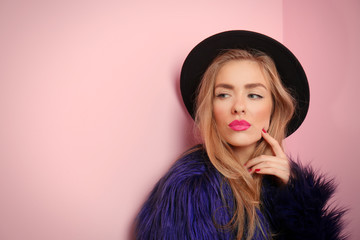 Young cool woman on pink wall background