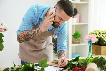 Crédence de cuisine en verre imprimé Fleuriste Handsome florist accepting order by mobile phone