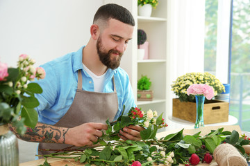 Handsome florist preparing bouquet at workplace