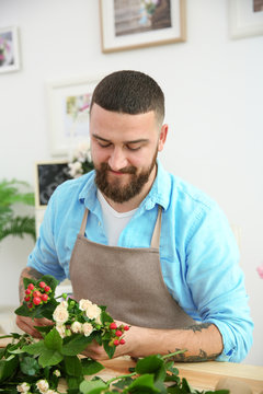 Handsome florist preparing bouquet at workplace