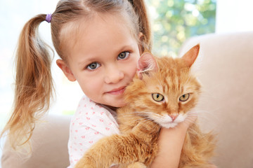 Cute little girl with red cat at home, close up