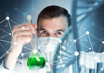 Young scientist mixing reagents in glass flask in clinical laboratory
