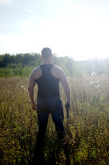 A man with a gun in his hands.Back view