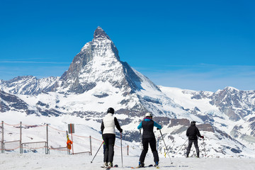 People are playing ski with Matterhorn peak background, Zermatt Switzerland, during clear sky day.