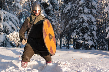 Swordsman in the winter forest in historical armor
