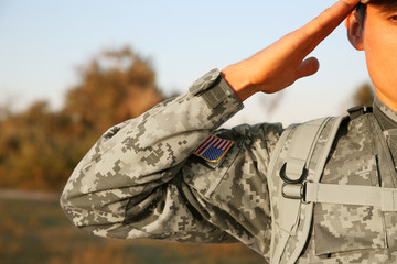 Soldier in camouflage taking salute outdoors, close up view